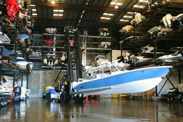 Large center console boat on lift in boat storage bay